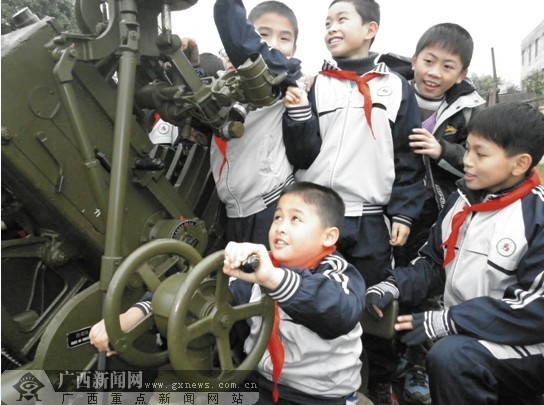 南宁200多名小学生观看军事演练 体会高射炮操作